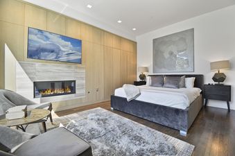 The luxurious bedroom at Parkite 34 boasts a king-sized bed, a large fireplace, and a sleek TV, offering ultimate comfort and entertainment.