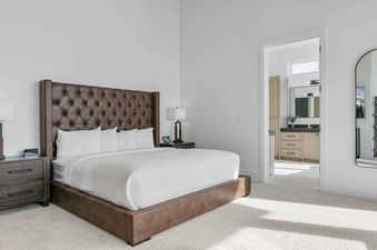 A spacious bedroom with a king-size bed and tufted leather headboard in SkyRidge 1152.
