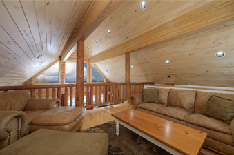 The loft at 2665 Golden Eagle Drive is decorated with rustic wood and comfortable brown leather sofas.