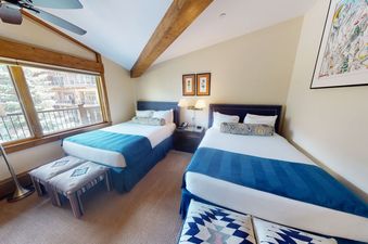 Manor Vail 212 offers two beds in the bedroom, with a comfortable-looking seating area near the window.