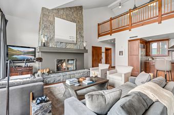 Living room of Hummingbird Overlook at Hummingbird Lodge featuring a massive stone fireplace.