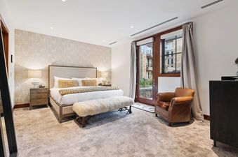 The Solaris 3BS features a beautifully appointed master bedroom with a large bed, elegant decor, and a direct outdoor access through a glass door.