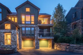 Exterior view of Lynx at the Terraces at dusk showing stone and wood architecture.