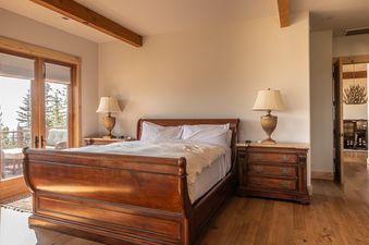 Inviting bedroom at Hitch Haven 3041 with a wooden sleigh bed and access to a scenic balcony.