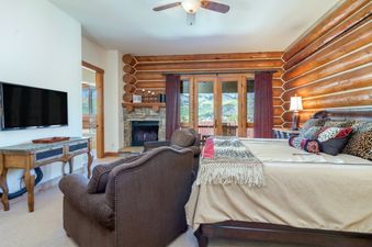 The bedroom in Townhomes On The Creek 119 features a cozy fireplace and exterior views.