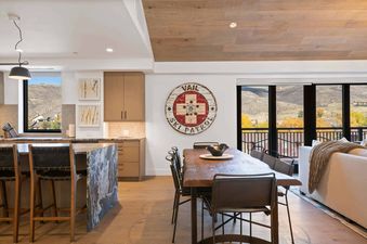 A modern open-concept kitchen and dining area with mountain views through large windows.