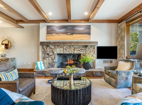 Cozy living room at 304C Bear Paw Lodge featuring a stone fireplace and elegant rustic seating.