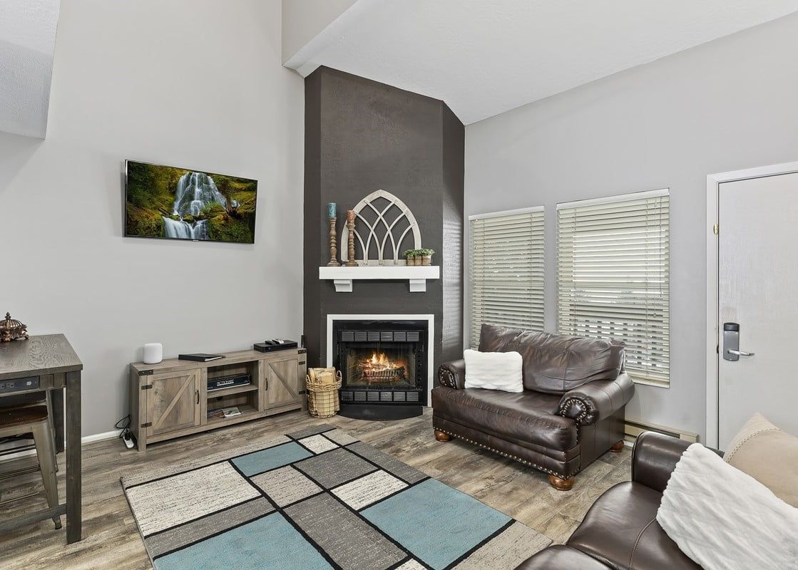 Wolf Lodge Condo 1412 features a fireplace, a large living room with a comfortable couch, and a flat-screen TV.
