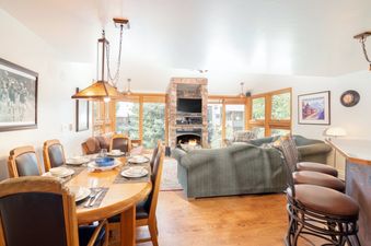 The dining and living area of Telluride Lodge 411 offers a warm and inviting space for relaxation and meals.