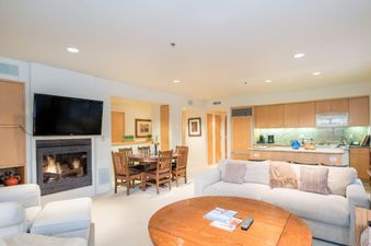 Living area of Penthouse At The Peaks 746 with fireplace, kitchen and dining area.