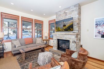 A living room with a fireplace and a TV showing a ski resort.