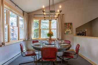 Dining table and chairs under a chandelier in Moose Creek 1.