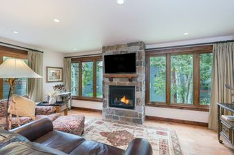 Cozy living room with a stone fireplace and large windows at Telluride Lodge 308.