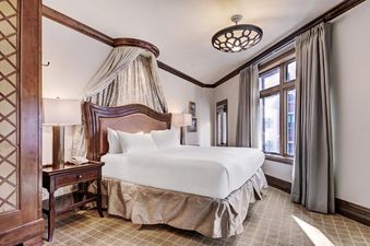 Elegant Arrabelle King Suite bedroom showcasing a plush king bed with a canopy.