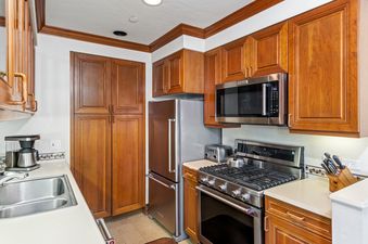 A well-equipped kitchen with stainless steel appliances and warm wood cabinetry offers a functional and inviting space for cooking and dining within Plaza Lodge 3 Bedroom Gold Unit 2.