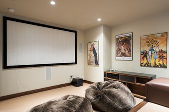 A home theater at the Silver Star 40 with a large projection screen, two oversized bean bag chairs, and movie posters on the wall.