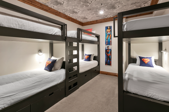 The bunk beds in Grand Lodge Four Bedroom 302 feature a fun superhero theme, with each bed having a pillow with a Superman logo.