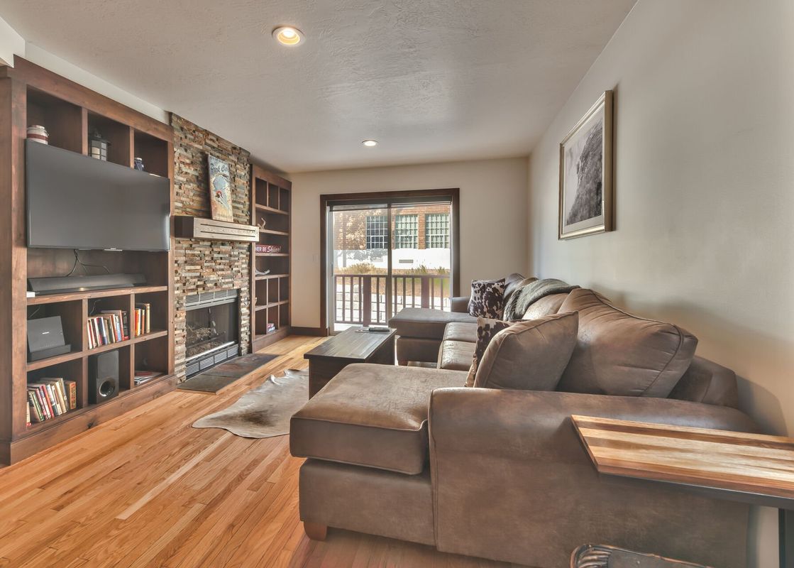 Entry into Spacious Living Room with Comfortable Seating, Smart TV and Gas Assist Fireplace with Beautiful Hardwood Floors