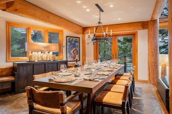 An elegant wooden dining table set for guests in the rustic-modern interior of Horstman 4930.