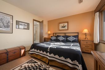 Warmly decorated bedroom at Whiteridge A4 with a southwestern-style bedspread, wooden furniture, and an adjoining bathroom view.