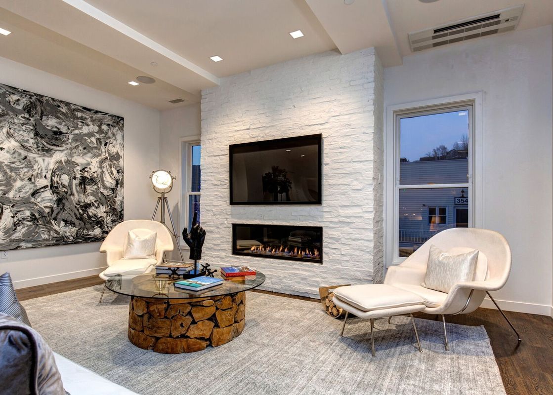 A cozy living room in Abode at the Parkite with a modern fireplace and stylish furnishings.