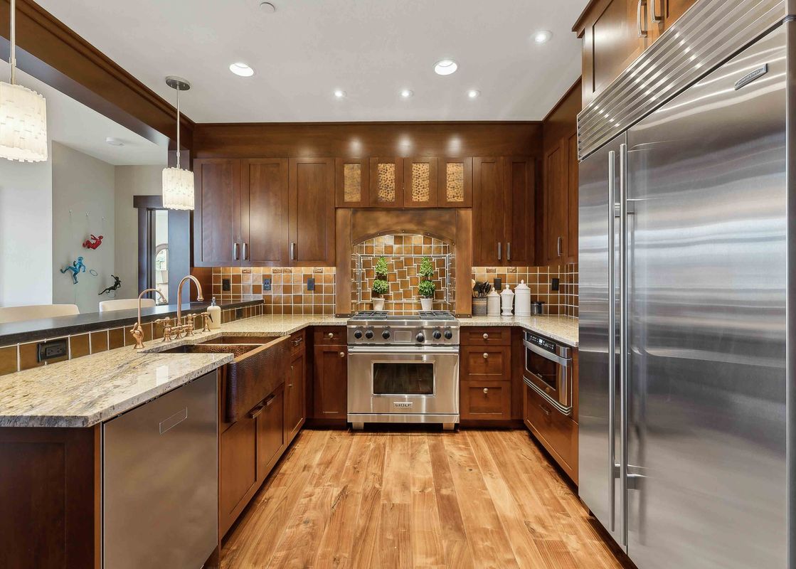 Empire Chalet at Flagstaff Lodge's kitchen boasts modern stainless steel appliances and a copper farmhouse sink, creating a stunning and functional space.