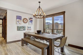 A dining table and chairs with a view of a mountain town.