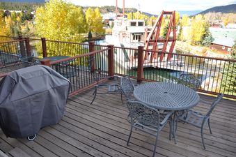 A view of the patio on a balcony overlooking a lake and mountains.