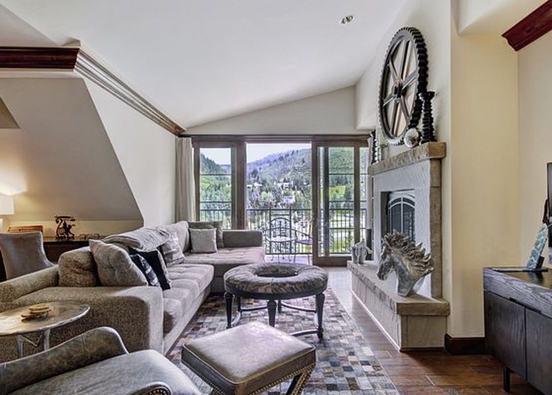 The living area of the Ritz Carlton 2BR Valley View with a large sectional couch, a coffee table, and a stone fireplace.