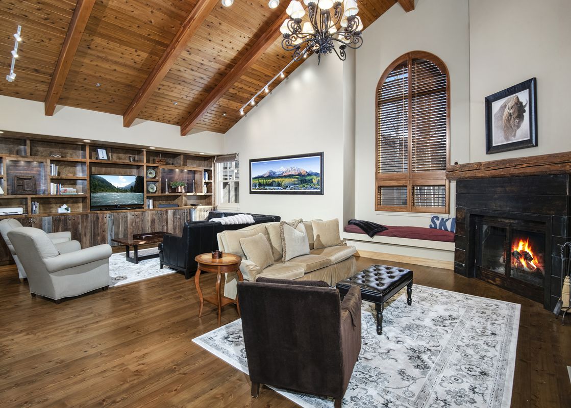 Spacious living room at Buffalo Park 3 with a rustic fireplace, vaulted wooden ceilings, and comfortable seating.