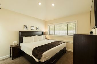 The primary bedroom at Deer Valley Daystar 1793 features a large bed with a dark wooden headboard and a television mounted on the wall.