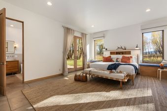 Bright and spacious bedroom at Alpenglow Jackson Hole with large windows and an en-suite bathroom.