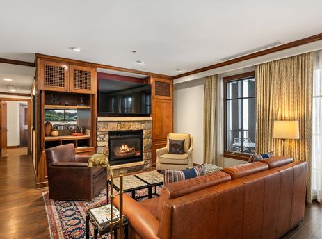 The living room of Elkhorn Premier 8405 features a cozy fireplace, comfortable seating, and large windows with elegant drapes.