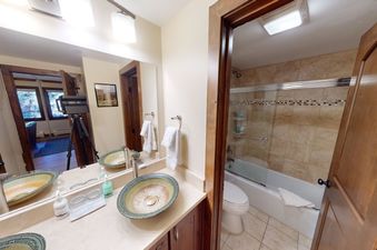 A bathroom with two sinks, a large mirror, and a separate shower and bathtub.