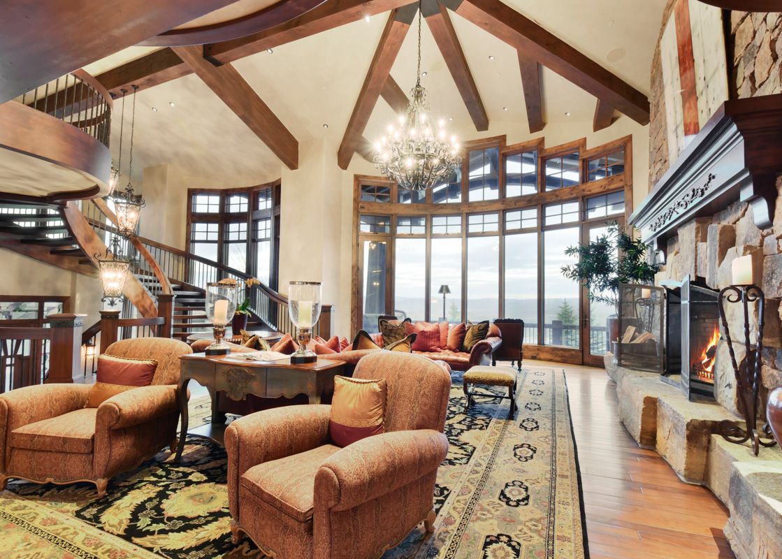 A lavish living room at Ski Dream Home with a grand fireplace, plush seating, and expansive windows offering stunning views.