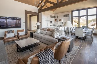 A wide view of the open-concept living, kitchen, and dining areas in Inspiration Point Townhome 14A, showcasing modern decor and a mountain view from the windows.