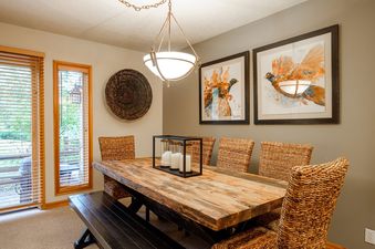 The dining area in Deer Lake Village Abode is beautifully furnished with a rustic wooden table and wicker chairs.