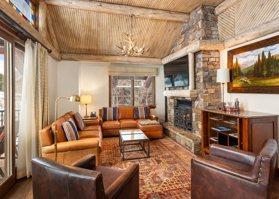 Cozy living room in Ritz Carlton Club 3 Bedroom Penthouse 4302 with stone fireplace and comfortable leather seating.