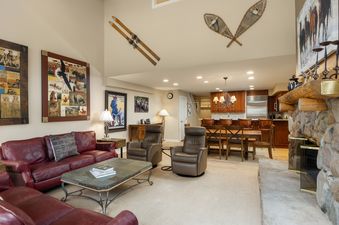 Living area in Montaneros 416, featuring a stone fireplace and comfortable seating.
