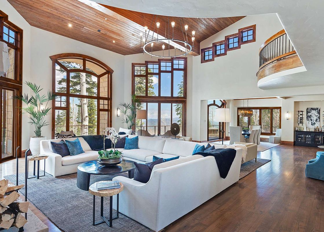 The grand living room at Alpenglow at the Colony welcomes guests with its impressive scale and refined rustic elegance.