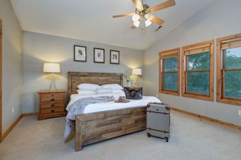 A cozy bedroom at Abode Mountainside features a rustic wooden bed frame and soft, inviting decor.
