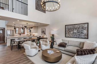 A wide shot of the Woodrun Place 56's open-concept living room, dining area, and kitchen, featuring stylish furnishings, modern appliances, and elegant decor.