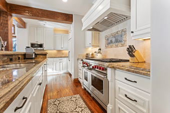 The kitchen in Grand Lodge Five Bedroom 402 features stainless steel appliances, granite countertops, and white cabinets.