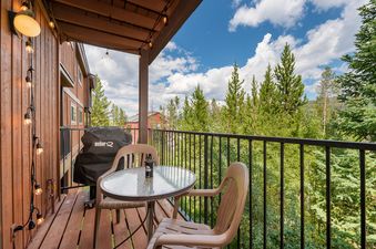 A close-up view of the balcony at Beaver Village 823, featuring a grill and an outdoor dining area.
