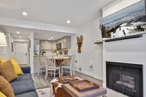 A cozy living room with a fireplace, a large flat-screen TV, and a comfortable couch.
