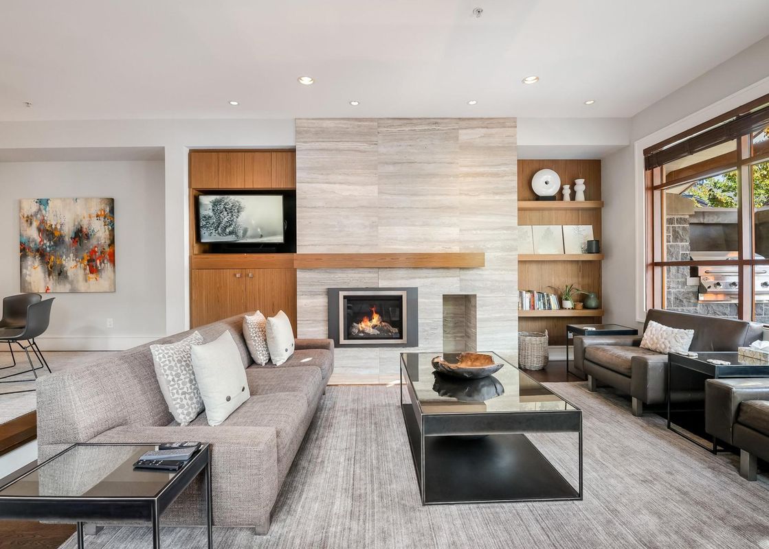 Modern living room with a large fireplace, grey sofa, and stylish decor at Fitzsimmons Walk 39.