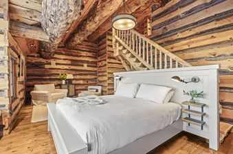 The Treehouse in Canyons Village bedroom features a king-size bed, wooden floors, and a rustic log cabin interior.