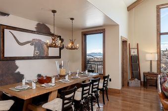 Dining area at Edgemont 2803 Nightfall Ridge featuring a rustic wooden table and antler chandeliers.