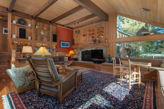 Cozy living room with wood paneling and stone fireplace in the Barry House.
