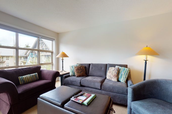 A spacious living area in Aspens on Blackcomb Unit 461 with comfortable sofas and large windows.